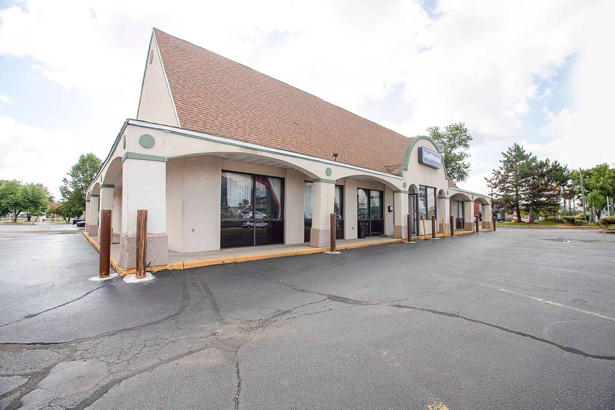 A building with a sloped roof, large windows, and a sign that reads 'Hotel.'