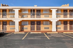 A two-story motel with a parking lot in front.