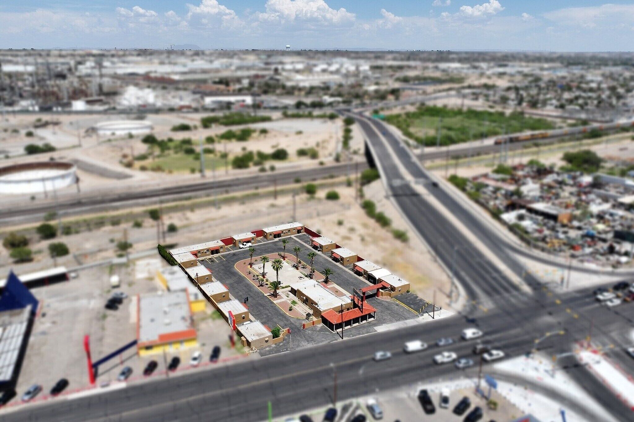 Vista aérea de un estacionamiento con varios edificios, una glorieta y una autopista.