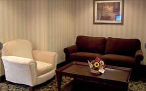 A room with a beige armchair, a brown sofa, and a coffee table with a floral arrangement. - 1 Bedroom Cabin|East Stroudsburg (East Stroudsburg)