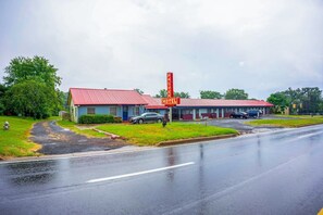 Un motel con techo rojo y un letrero alto.