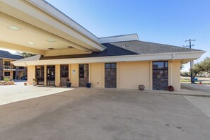 A building with a covered entrance, large windows, and a flat roof. - King Bed with Pull Out (Ingleside TX)