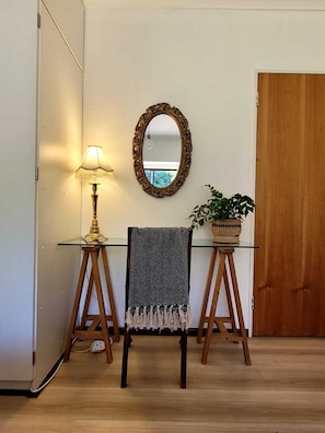 A room with a glass table, a chair, a mirror, a lamp, and a potted plant. - Elegant two-bedroom hideaway in picturesque Stellenbosch. (Stellenbosch)