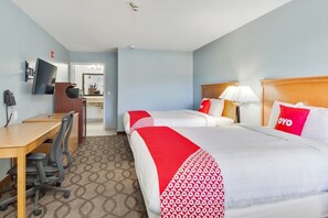 Une chambre d’hôtel équipée d’un lit, d’un bureau, d’une chaise et d’un téléviseur.