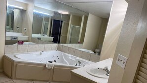Une salle de bain avec une grande baignoire, un lavabo et un miroir.