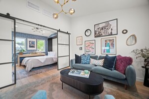 Una sala de estar moderna con un sofá, una mesa de centro y obras de arte en las paredes.