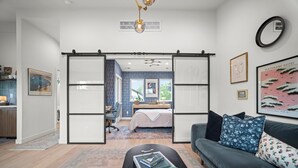 A modern living room with a sofa, a coffee table, and a desk area.