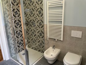 Un bagno con doccia, bidet e WC.