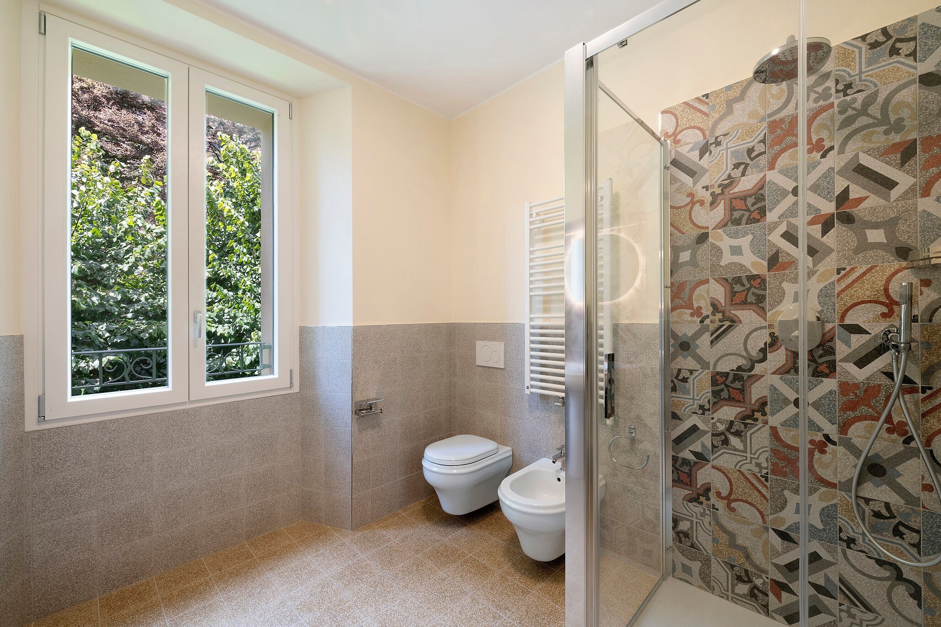 Une salle de bain avec douche, toilettes et fenêtre.