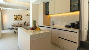 Una cucina moderna con un piano di lavoro in marmo, una macchina da caffè e un'area pranzo con un divano e sedie.