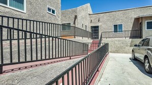A building with a stone facade, a metal staircase, and a parked car. - @ View Suite with private entrance, Lounge and sofa bed and bar. (Los Angeles)