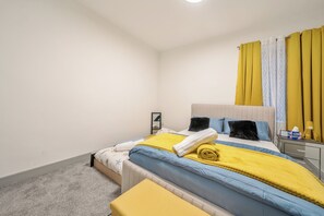 Une chambre à coucher avec un lit, une table de chevet et un miroir.