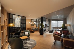 Ein modernes Interieur mit einer Sitzecke, einem Esstisch und einem großen Fenster.