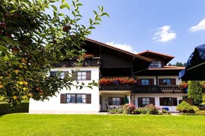 A two-story building with a balcony, a garden, and a tree with fruit. - Basement - Lake view (Hopfen am See)