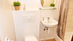 Un bagno con servizi igienici, lavandino e doccia.