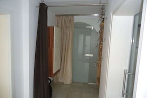 A bathroom with a shower, a toilet, and a glass door leading to a shower area. - A in the Sommertal guesthouse (Meersburg)