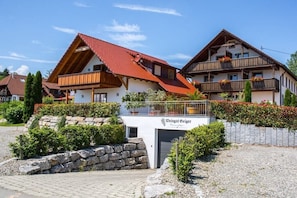 A traditional chalet-style building with a red-tiled roof, wooden balconies, and a sign indicating 'Weingut Geiger.' - Geiger - Säntisblick (Meersburg)