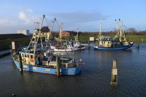 Três barcos atracados em um porto, com um edifício ao fundo.