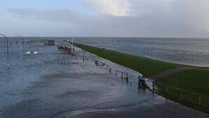 Une zone riveraine inondée comprenant une jetée, une pelouse et une route.
