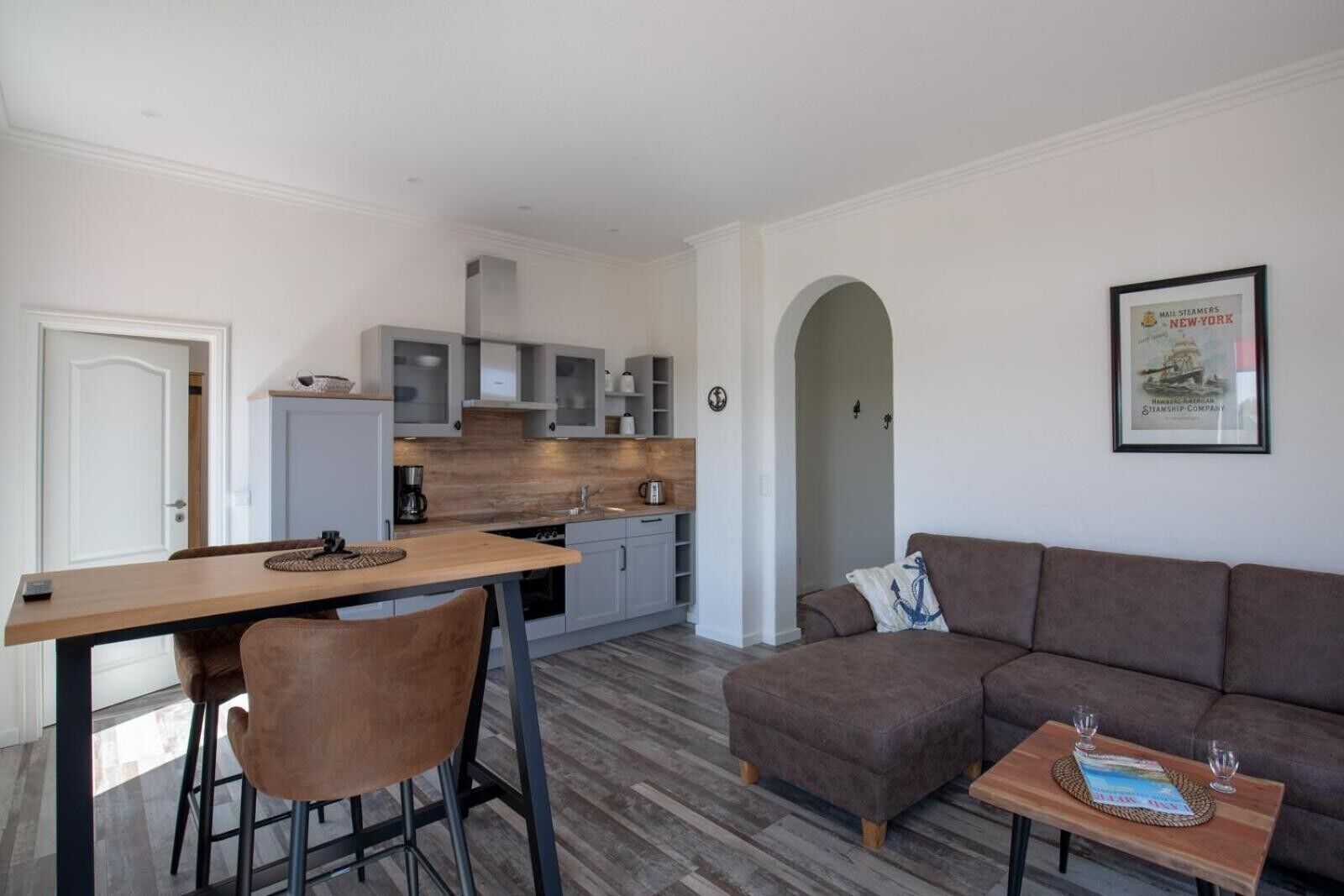A modern apartment with a dining area, kitchenette, and living room.