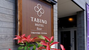 Señal de madera del Hotel Base Tabino en la estación de Takayama.