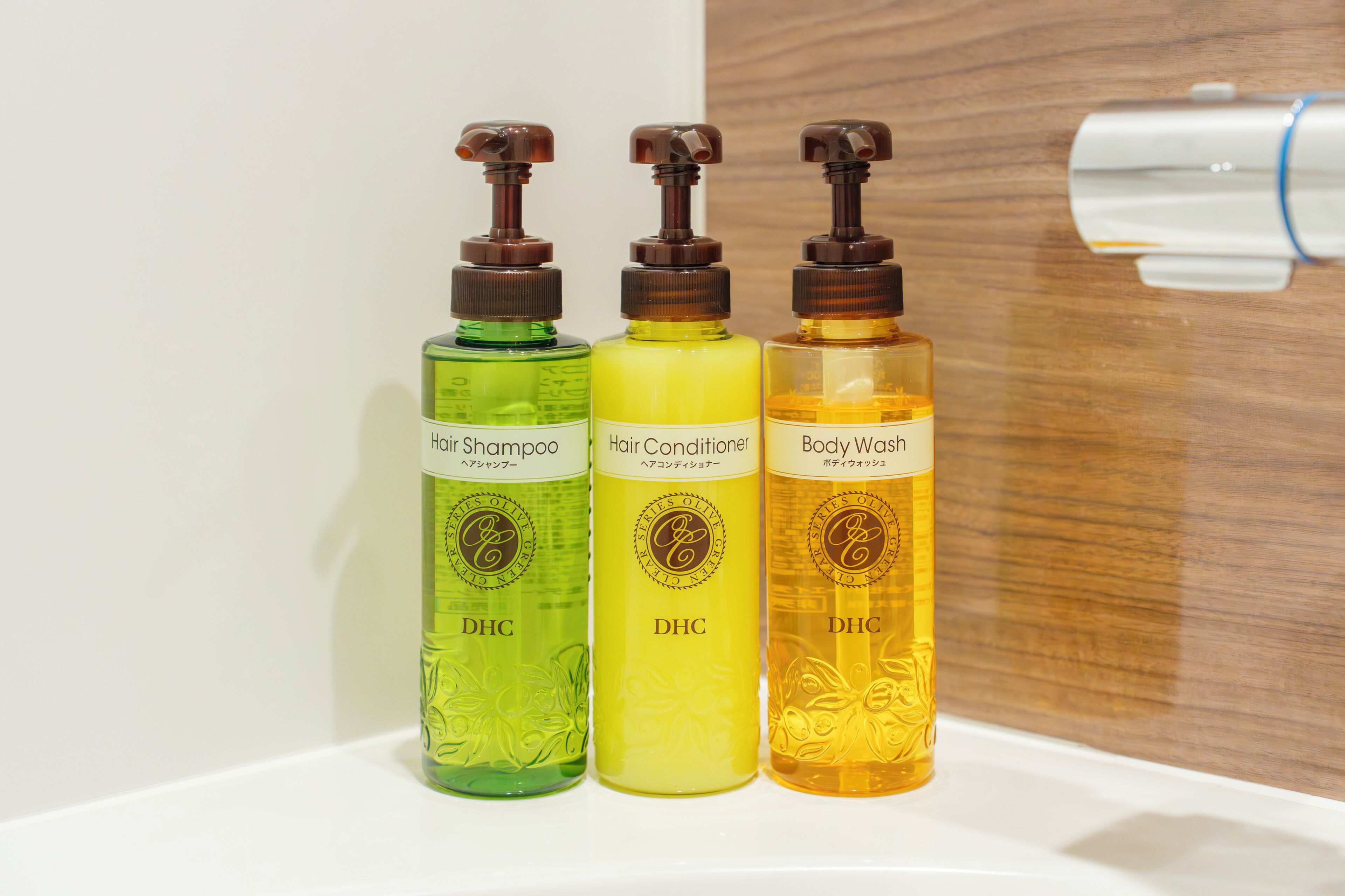 Three bottles of hair care products on a white surface.