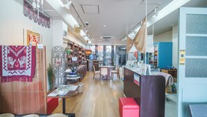 Un interior espacioso con suelo de madera, una zona de estar central y varias tiendas a los lados.