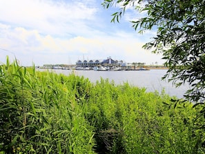 A waterfront property with a large house, docked boats, and lush greenery. - Family Villa With Ambient Fireplace (Tholen)