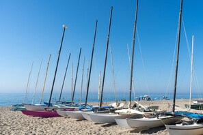 Ein Strand mit mehreren Segelbooten, die im Sand vor Anker liegen.
