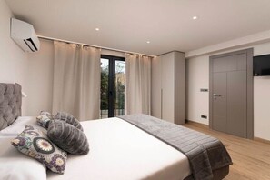Ein Schlafzimmer mit Bett, Vorhängen, einer Klimaanlage, einem Fernseher und einem Kleiderschrank.