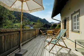 A wooden deck with a wooden fence, a table, and two chairs. - Villa Senz - Bliss (Pfronten)