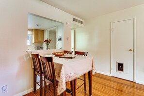 A dining area with a table, chairs, a mirror, and a door. - Steps to Fashion Square! Condo w/ Patio & Pool (Scottsdale)