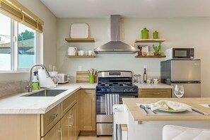 Une cuisine moderne équipée d’une cuisinière, d’un four, d’un four à micro-ondes et d’un évier.