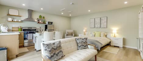 Un dormitorio moderno con cama, mesitas de noche y un atril.
