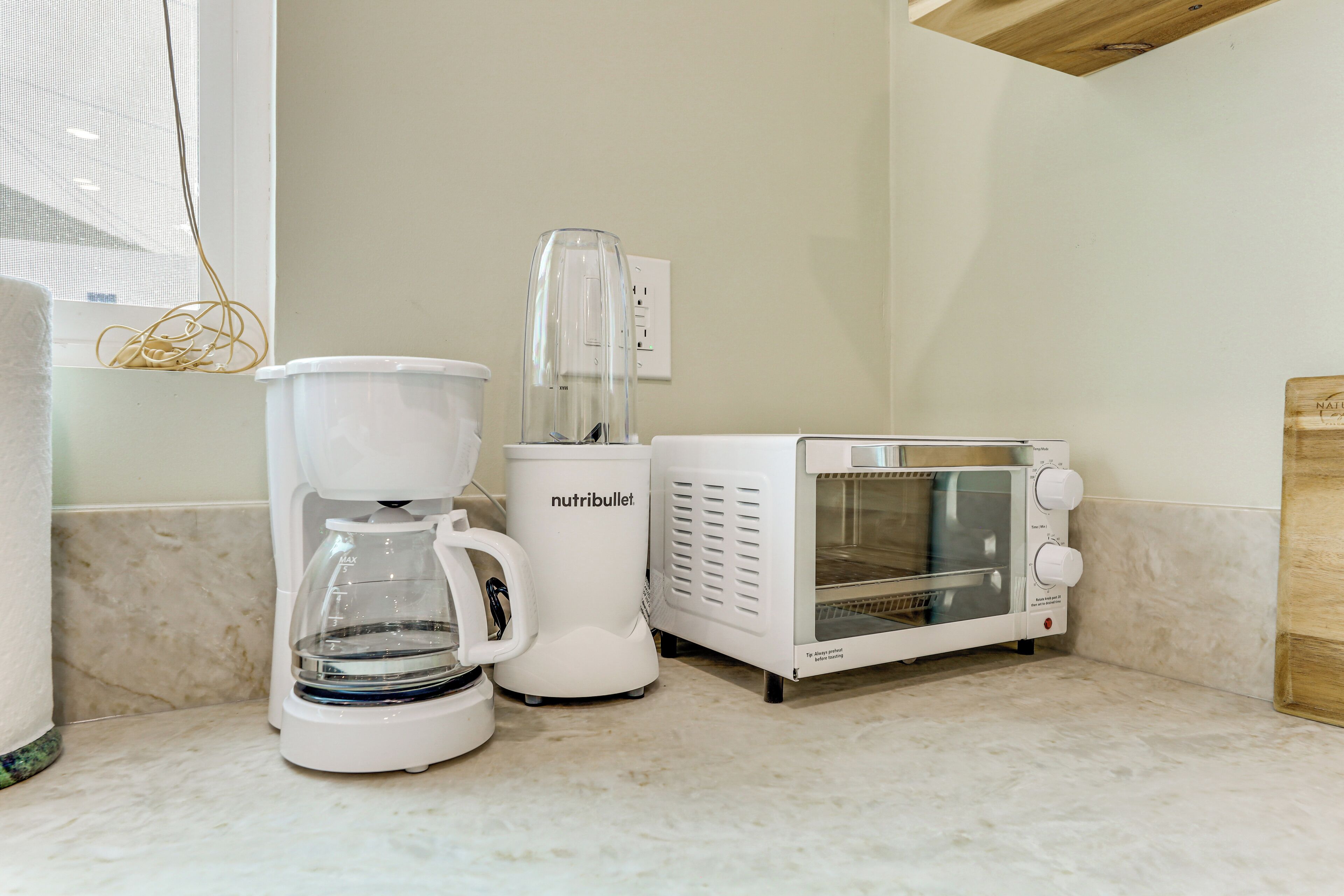 A kitchen with a coffee maker, a blender, and a toaster oven.