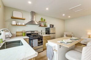 Eine moderne Küche mit einer zentralen Kochinsel, Backofen, Mikrowelle und Kühlschrank.