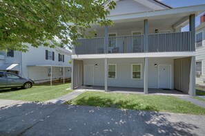 A two-story residential building with a balcony, a covered porch, and a car parked on the street. - Central Hinton Studio Near Dtwn & New River Gorge (Hinton)