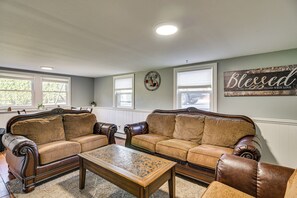 A living room with two leather sofas, a wooden coffee table, and a wall with a decorative sign. - 15 Mi to Gillette Stadium! South Easton Apartment (South Easton)