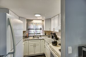 A kitchen with white cabinets, a stainless steel refrigerator, a sink, and a kettle on the counter. - 15 Mi to Gillette Stadium! South Easton Apartment (South Easton)