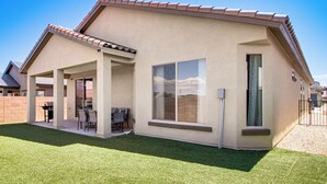 A single-story house with a covered patio, a barbecue area, and a large window. - Suburban Santa Fe Home Near Main Street & I-25 (Los Lunas)