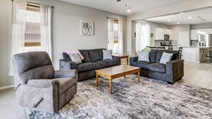 A living room with a sofa, armchairs, a coffee table, and a ceiling fan. - Suburban Santa Fe Home Near Main Street & I-25 (Los Lunas)