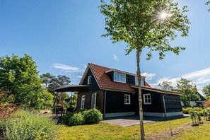 Ein zweistöckiges Haus mit Schrägdach, Garage und gepflegtem Rasen.