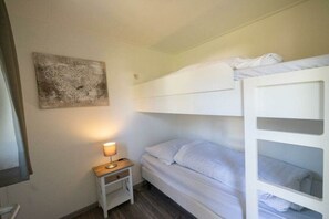 A bunk bed room with a bedside table, a lamp, and a wall art piece. - Holiday home in Lochem with terrace (Lochem)