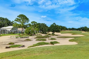 A golf course with sand bunkers, a clubhouse, and surrounding trees. - Private Pool! Family-Friendly Southern Dunes Home (Haines City)