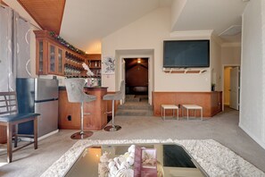 Eine moderne Küche mit Einbaukühlschrank, Holzschränken und einer Bar mit Hockern.