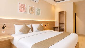 Una habitación de hotel moderna con una cama grande, mesitas de noche, un armario y obras de arte en la pared.