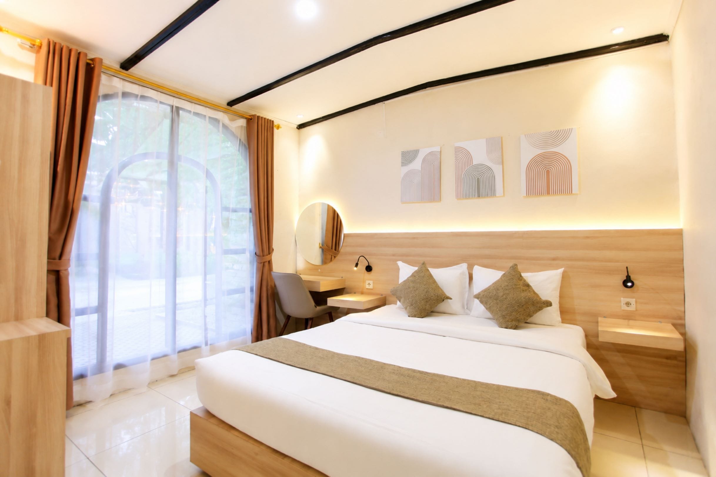 Habitación de hotel moderna con una cama grande, un escritorio, una silla y un amplio ventanal con cortinas.