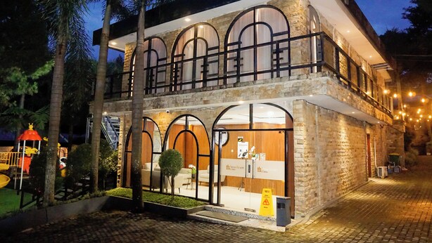 A two-story building with arched windows, a stone facade, and a visible reception area. - Nimo Resort Ciater (Ciater)