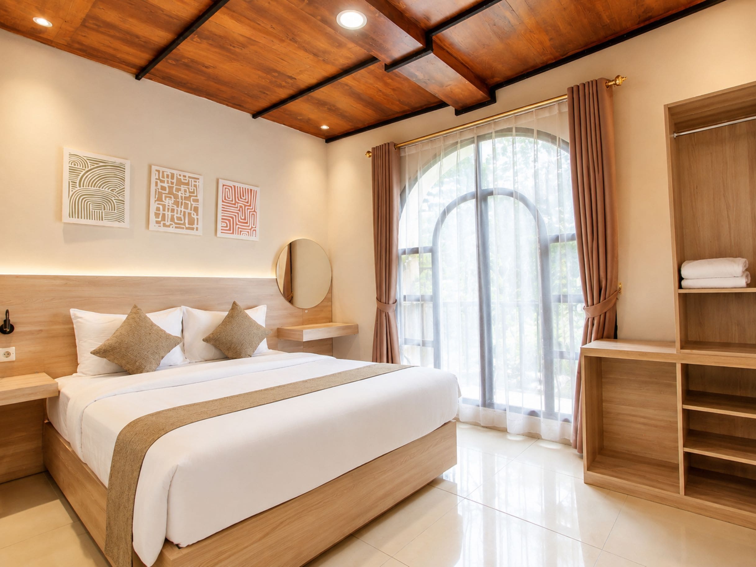 A modern bedroom with a wooden ceiling, a large bed with white bedding, a bedside table, a mirror, and a wardrobe.