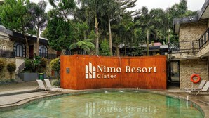 A pool area with a wooden sign for Nimo Resort. - Nimo Resort Ciater (Ciater)